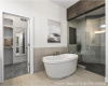 Bathroom featuring a shower stall, tile walls, and a freestanding bath