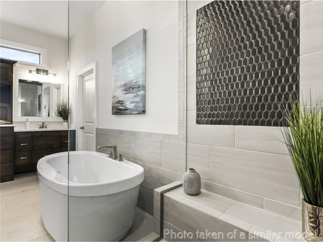 Full bath with a freestanding tub, vanity, and tile walls
