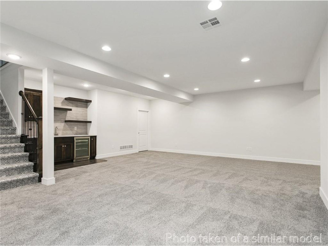 Finished below grade area with carpet flooring, wine cooler, recessed lighting, stairs, and baseboards