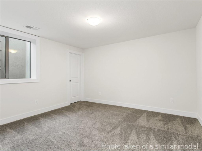Carpeted spare room with baseboards