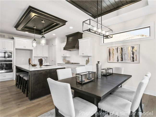 Dining space featuring light wood-style floors, recessed lighting, a chandelier, and a raised ceiling